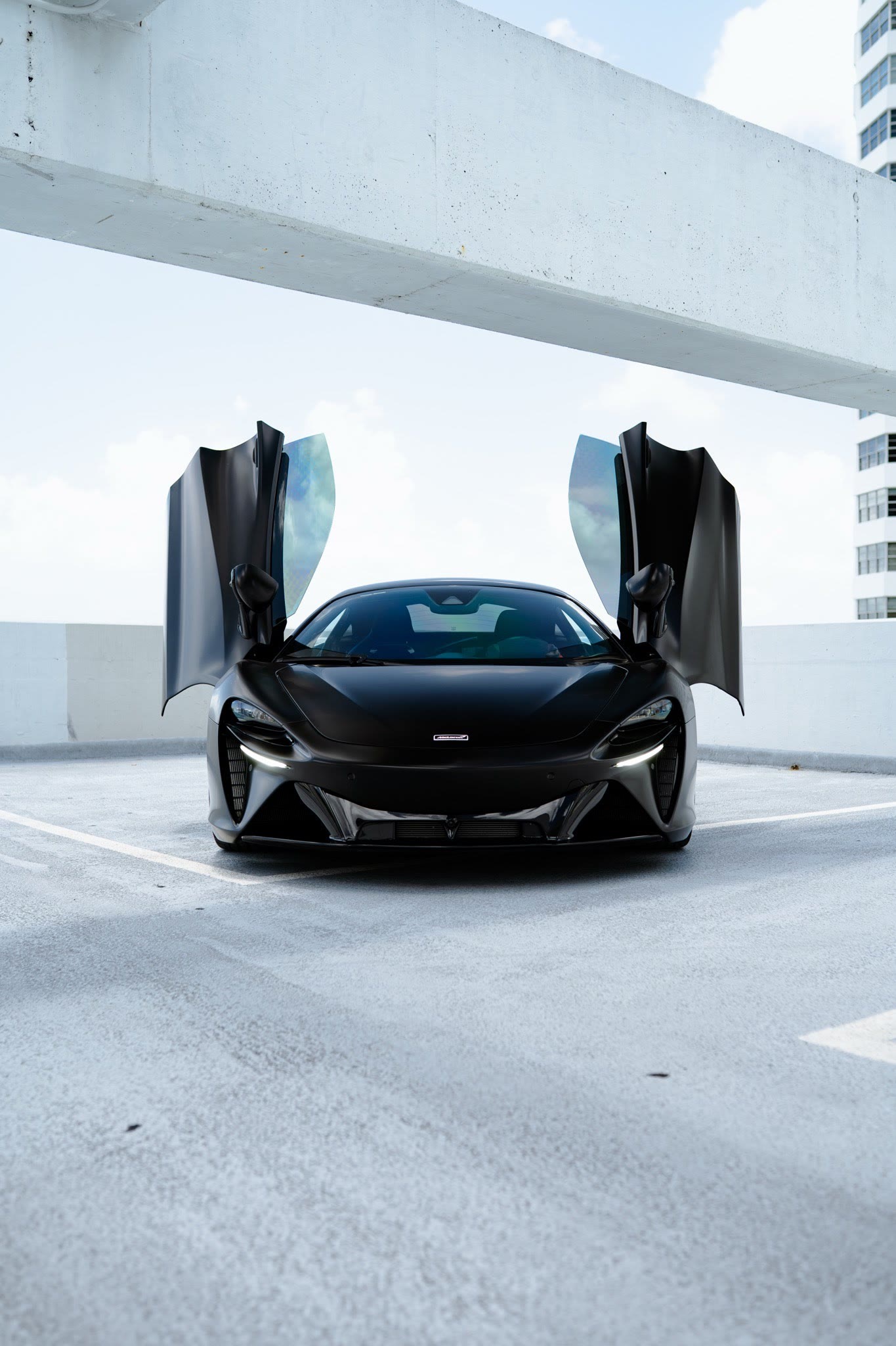Black McLaren with dihedral doors open, wrapped by Restyle Miami